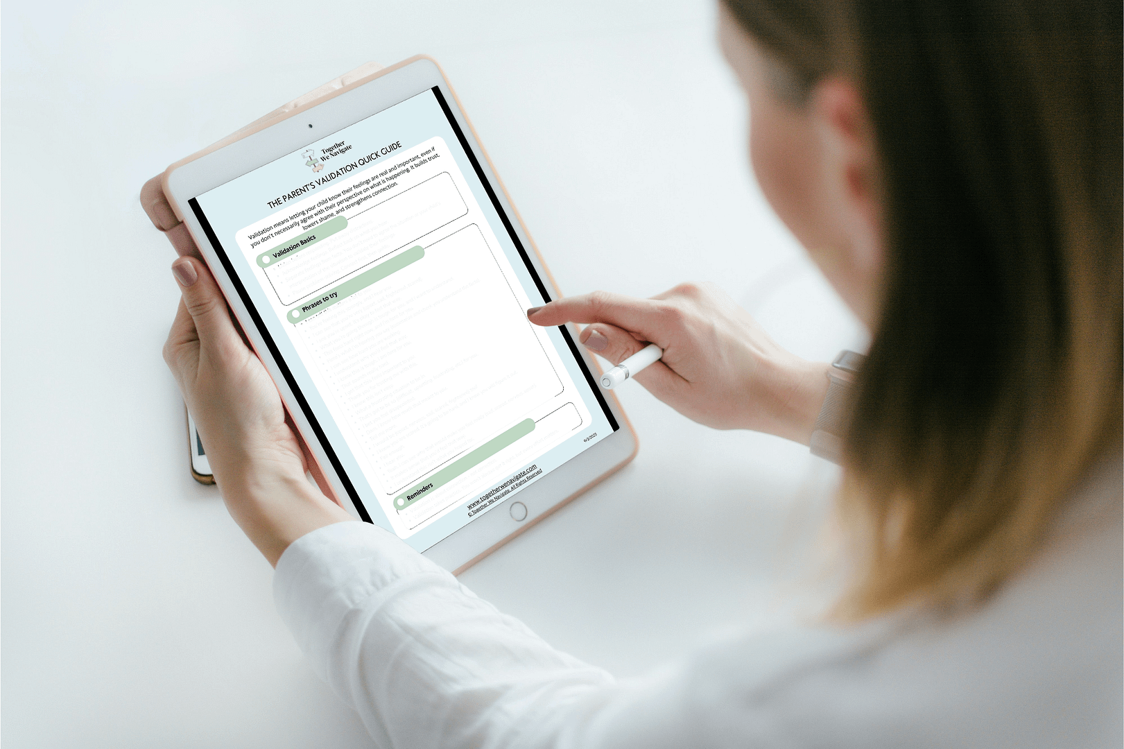 A parent viewing the Validation Quick Guide for Parents on a tablet.